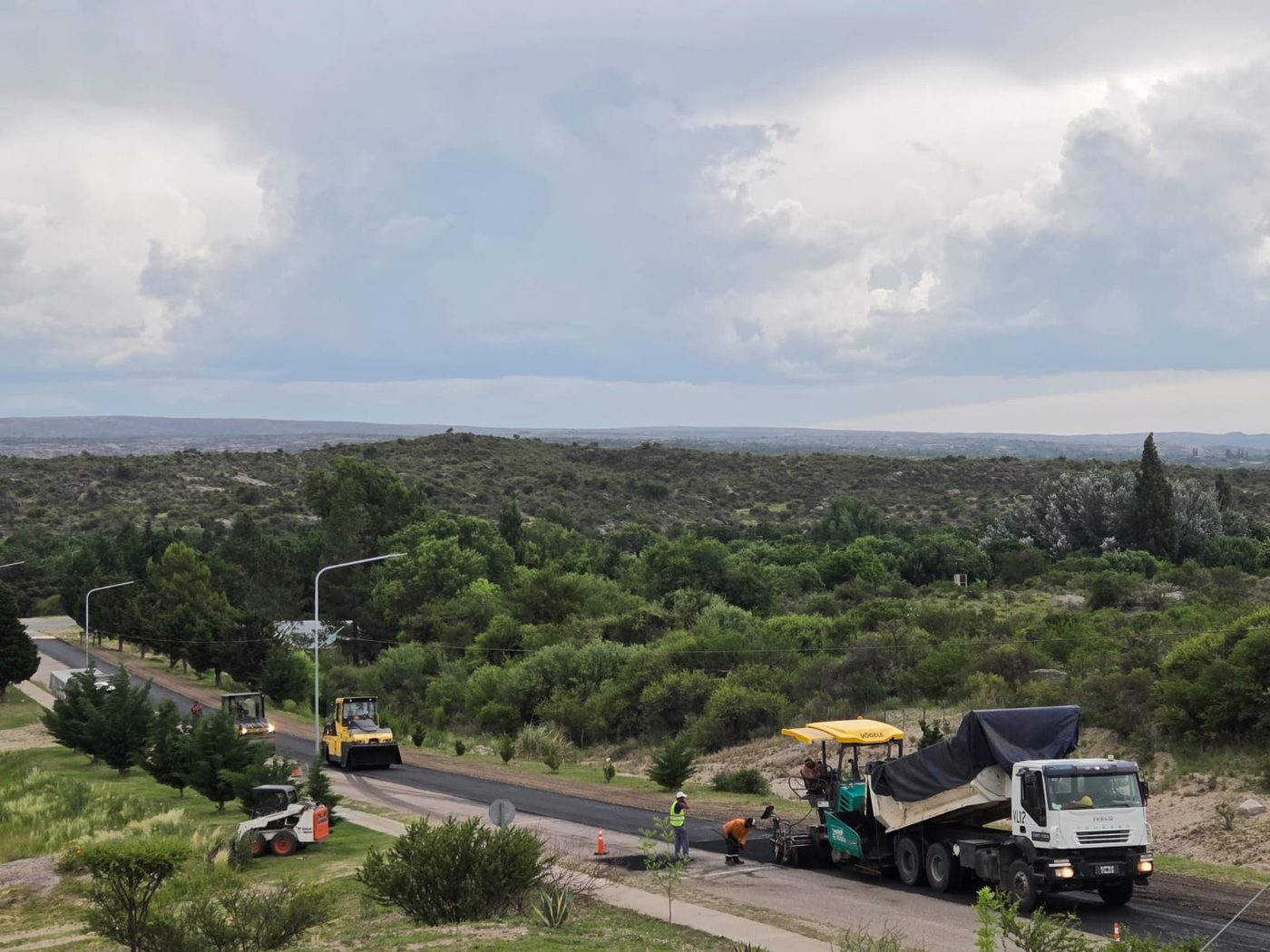 Obra vial en zona serrana con terminadora y rodillo compactador