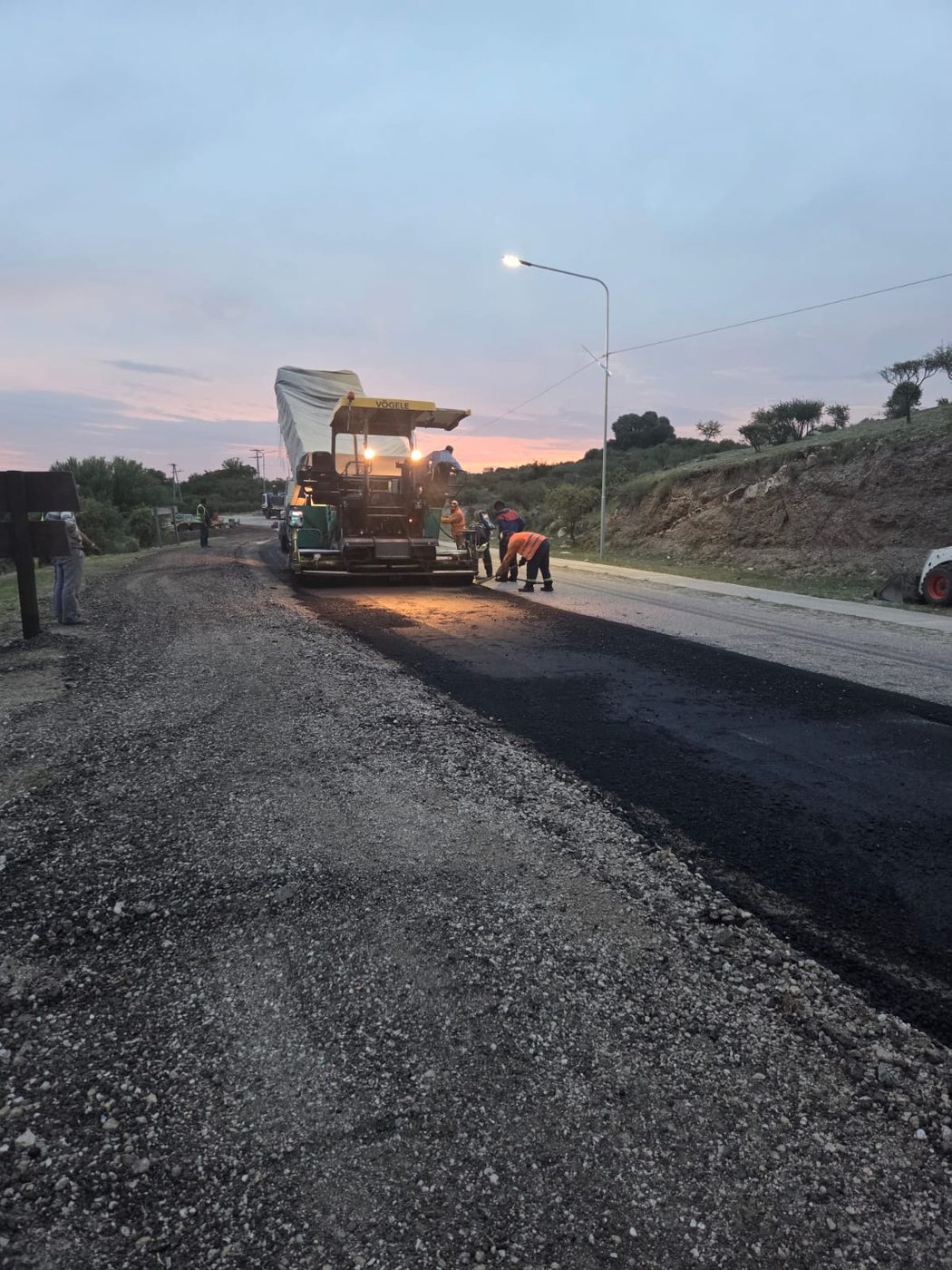 Cuadrilla de TPA pavimentando durante el atardecer